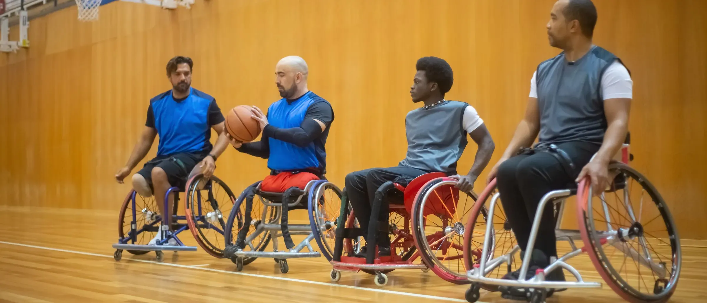 A wheelchair basketball team mid game on an indoor court